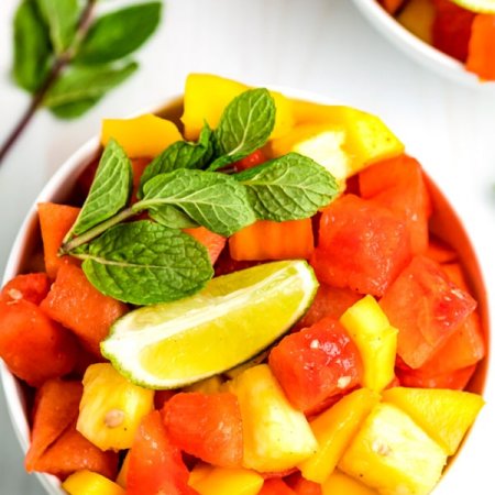 A close up overhead picture of Mexican fruit salad recipe in a white bowl.