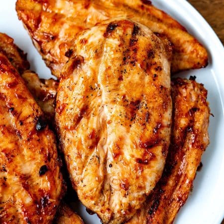 A close up picture of the finished Grilled BBQ Chicken Breasts on a white platter.