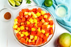 Place all of the fruit, except for the lime juice, in a large bowl.