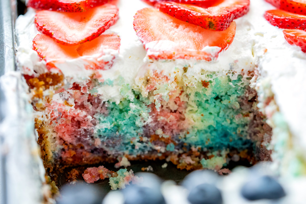 The inside of a 4th of July Poke Cake where you can see where Jell-o has been poured into the holes.