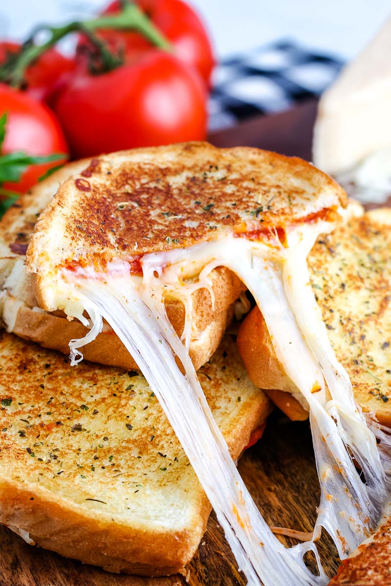One half of a Pizza Grilled Cheese with a cheese pull coming out of it. 