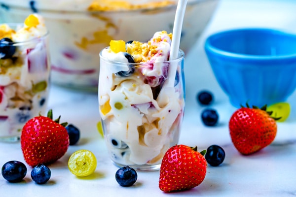 Cheesecake fruit salad in a clear glass serving cup.