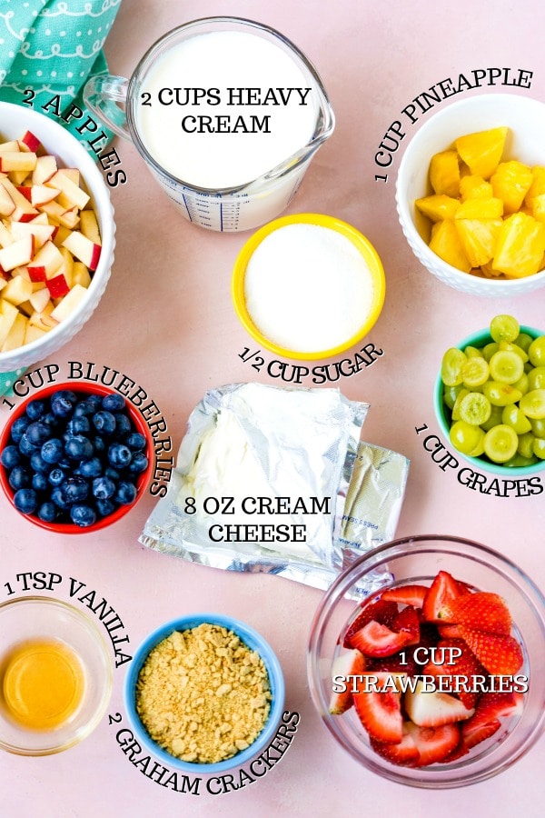 An overhead picture of all of the ingredients needed to make Cheesecake Fruit Salad with text overlay.