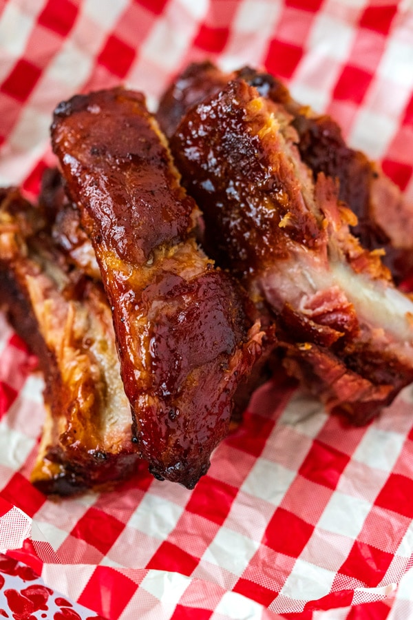 A close up picture of a pile of spare ribs that have been cooked on the grill.
