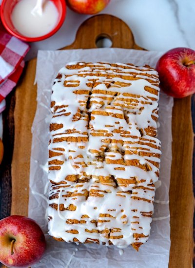 An overhead picture of a loaf of apple fritter bread drilled with icing.
