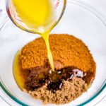 Butter being poured into a bowl with the other crust ingredients.