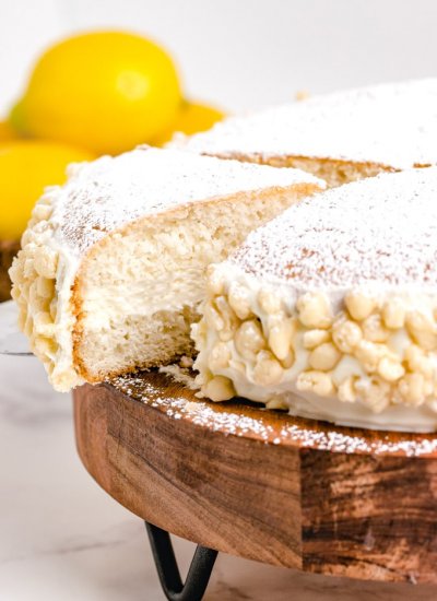A slice of cake being taken out of the whole cake.