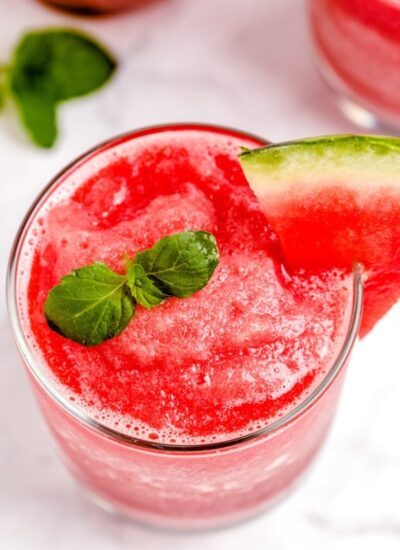 Overhead picture of smoothie in a clear glass that is garnished with a slice of watermelon.