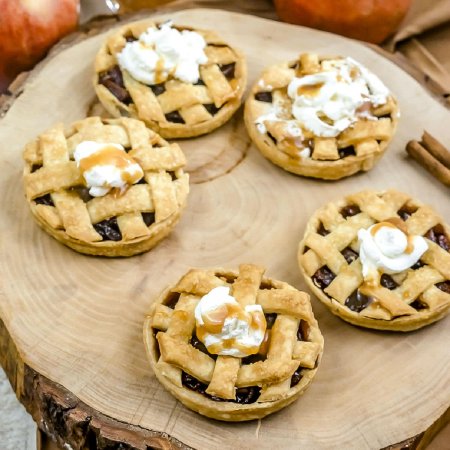 The mini pies on a wood serving plate.
