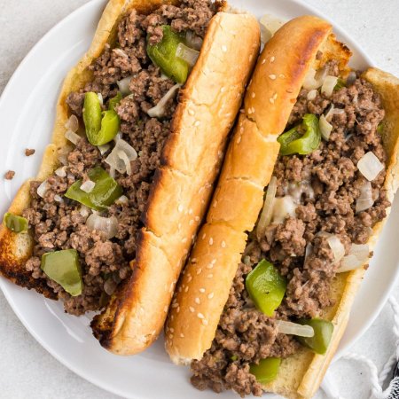 An overhead picture of two sloppy joes on a white plate.