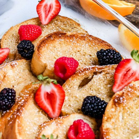A close up picture of the baked French toast in a casserole dish.