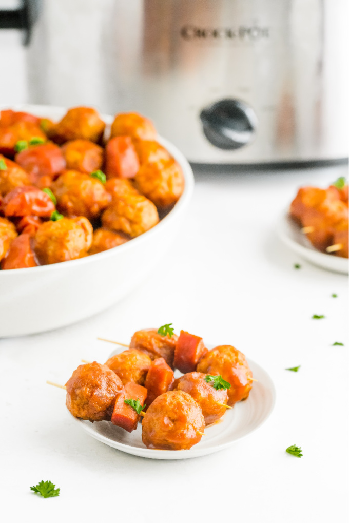 A picture of Cranberry Meatballs served as an appetizer with toothpicks or a main dish over white rice.