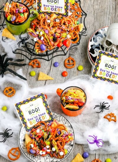Halloween Snack Mix in serving bowls with gift tags nearby.