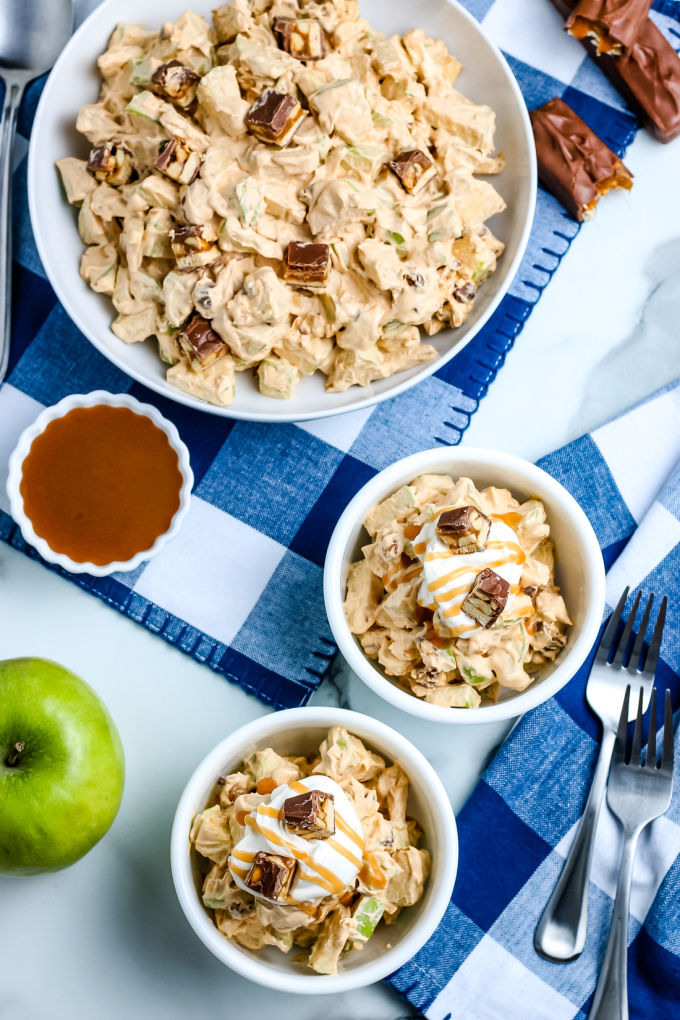 An overhead picture of Snickers salad in a large serving bowl and in small white bowls.