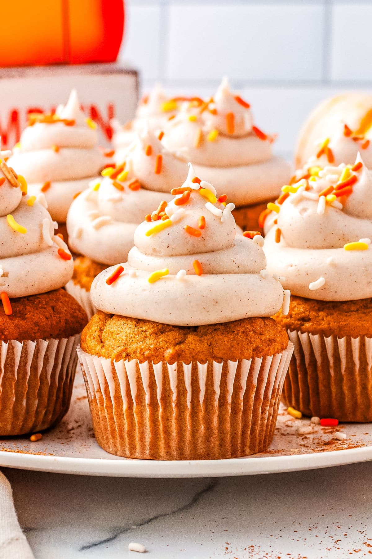 pumpkin cupcakes with cream cheese frosting on a plate
