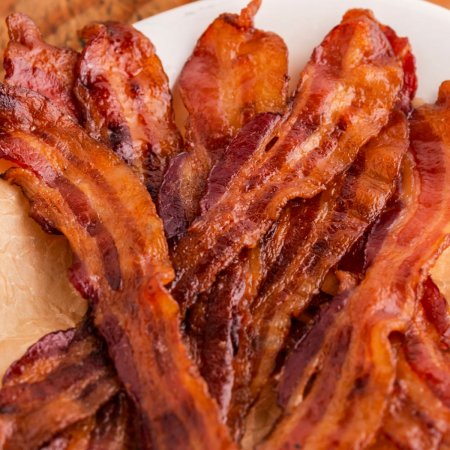 A close up picture of candied bacon strips piled on top of each other.