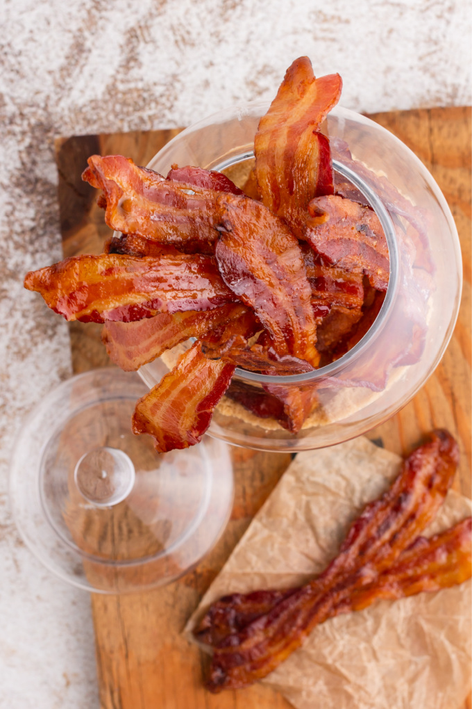 An overhead picture of candied bacon in a glass jar.