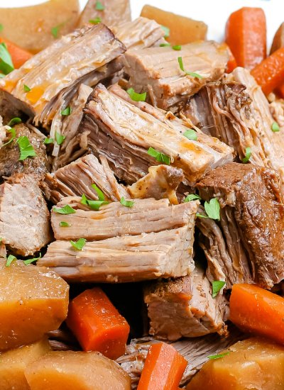 A close up picture of the finished slow cooker pot roast on a white platter.