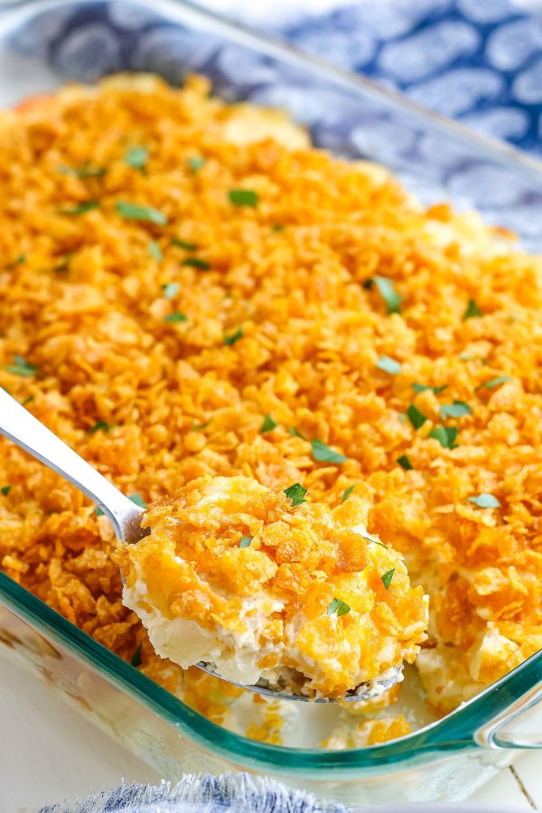 A spoon taking a scoop out of of the finished hash brown casserole.