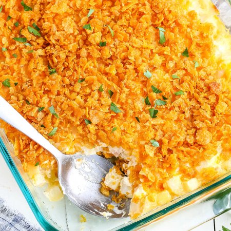An up close picture of the finished hash brown casserole with a scoop taken out of it.