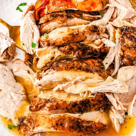 a plate of turkey breast with gravy on it
