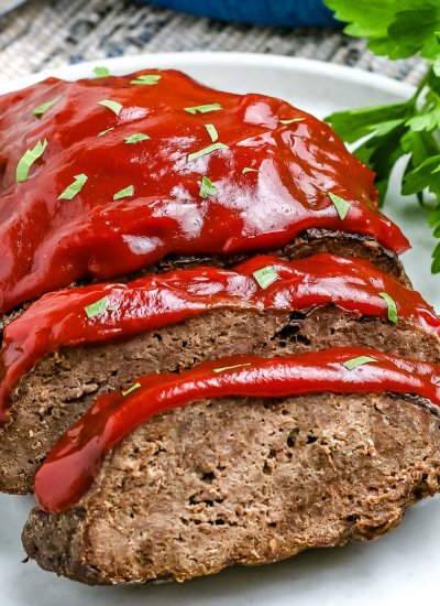 A closeup picture of slices of instant pot meatloaf on a white platter.