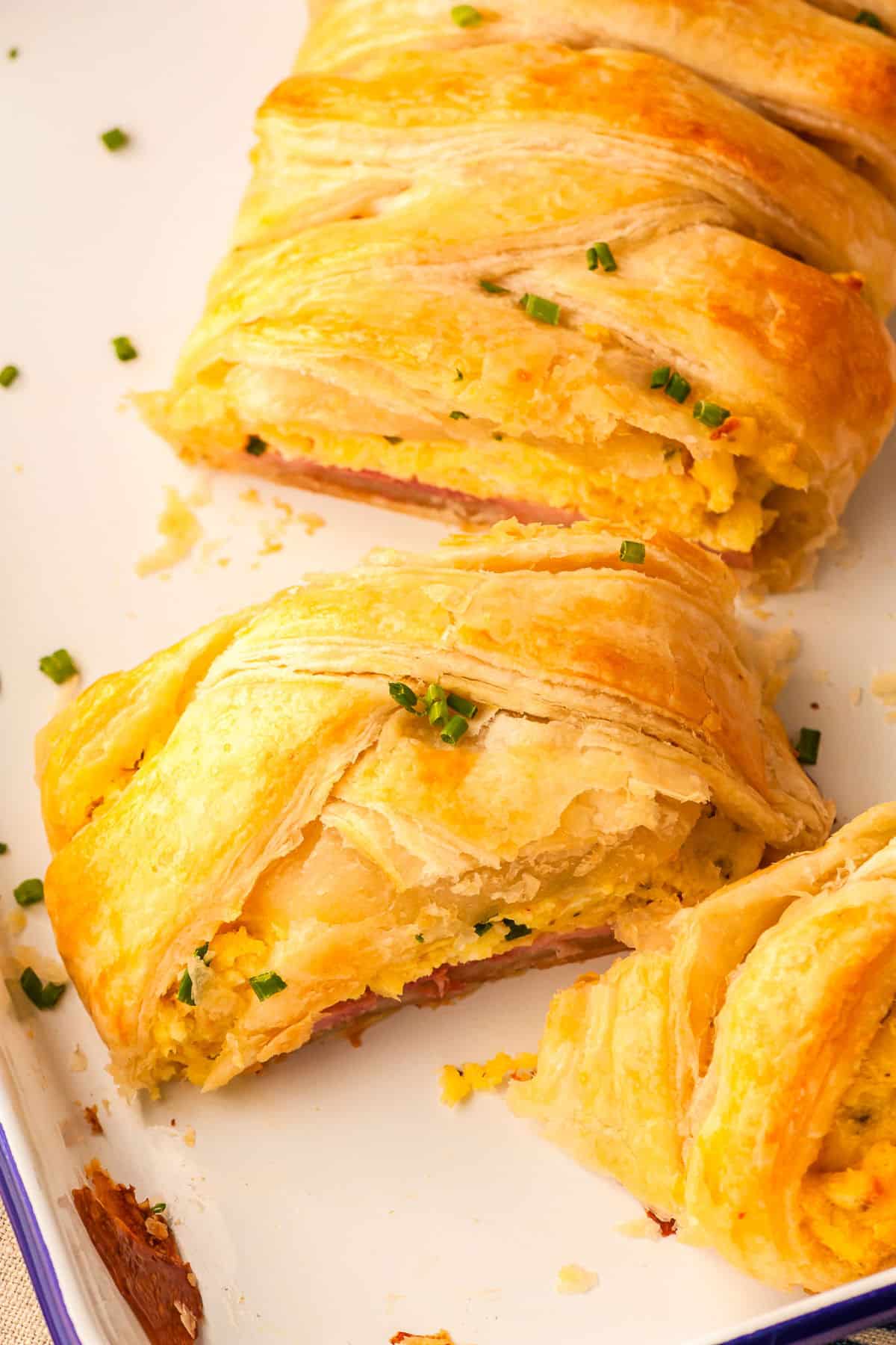 a slice of eggs benedict braid on a baking sheet