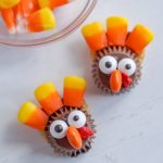 Two turkey Treats on a white surface with candy corns in the background.