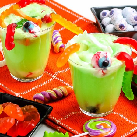 Two glasses of Witches' Brew with halloween candy in it.