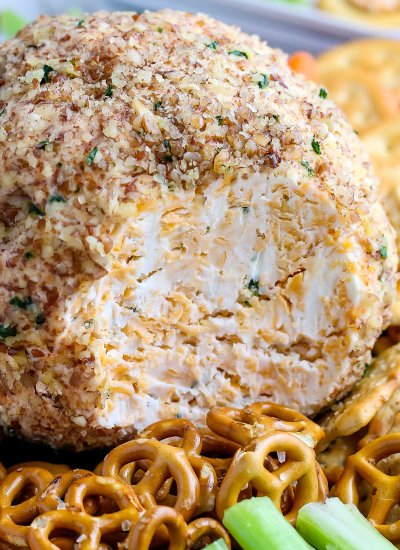 A close up picture of the cheese ball with a slice taken out of it.