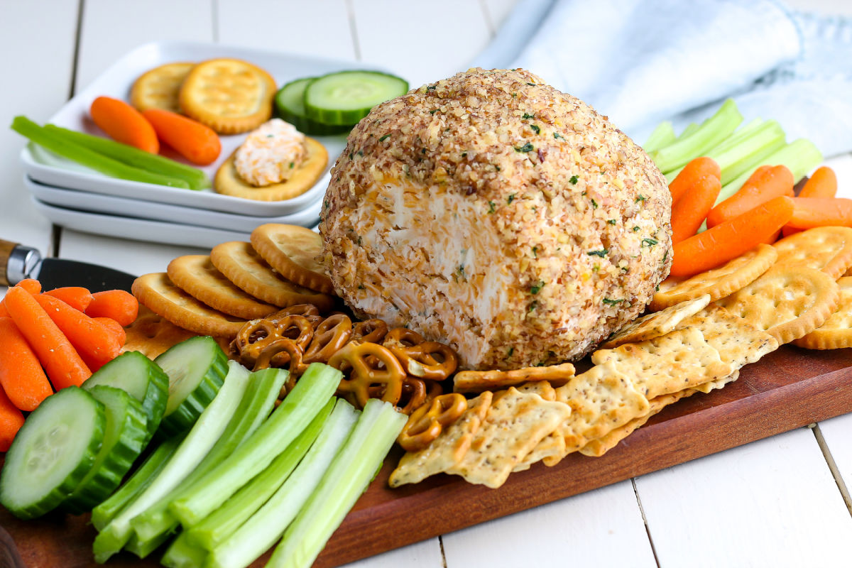 The finished classic cheese ball on a wooden serving board.