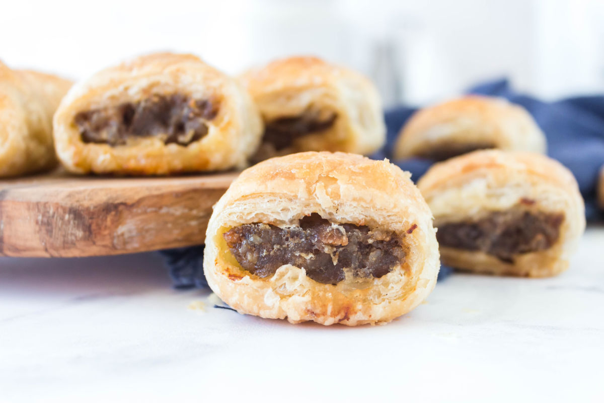 The finished sausage rolls on a wooden platter.