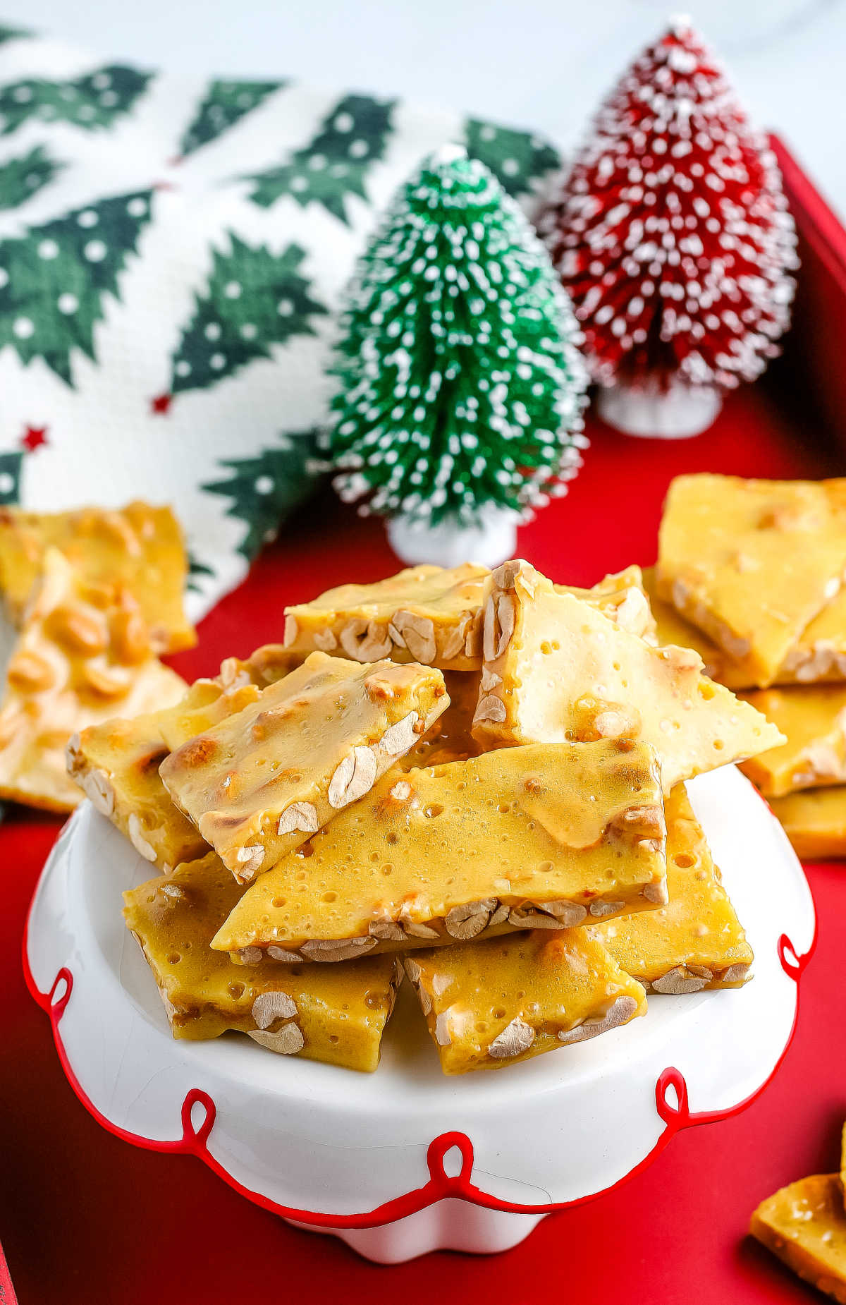 pieces of peanut brittle on a white cake stand.
