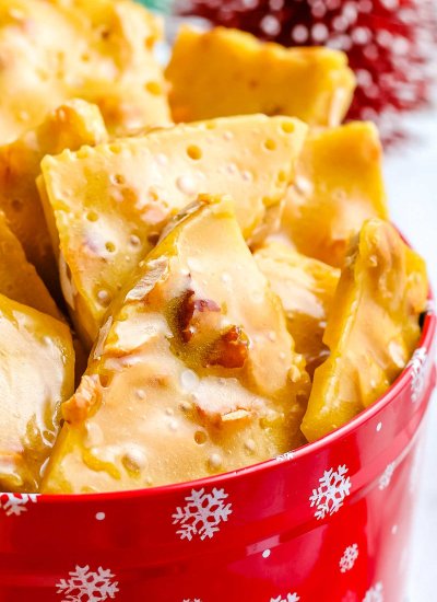 A close up picture of peanut brittle in a Christmas tin for gifting.