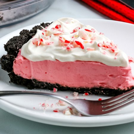 A close up picture of a slice of peppermint pie on a white plate.