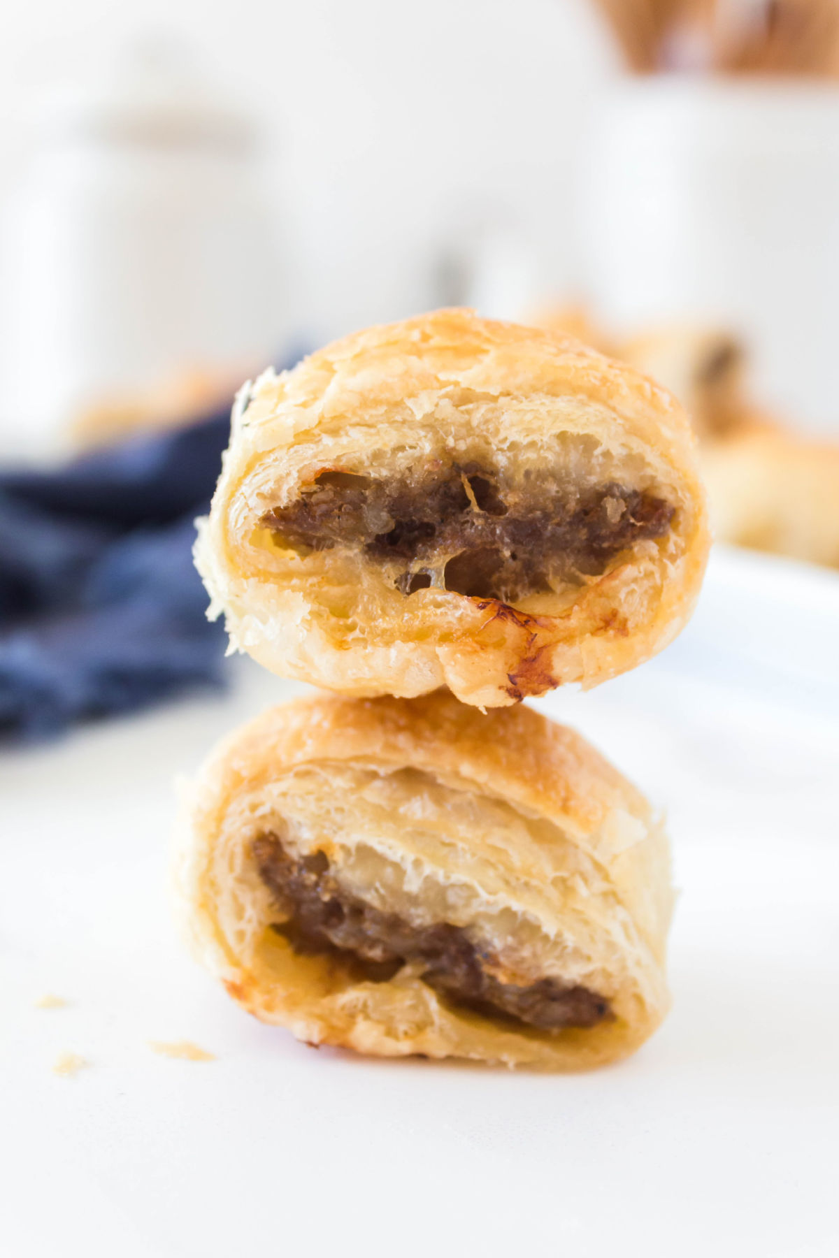 two sausage rolls stacked on tip of each other.