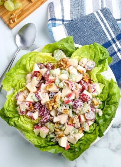 An overhead picture of the finished healthy Waldorf salad on a bed of lettuce.