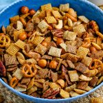 A close up picture of the finished Chex Mix in a blue bowl.