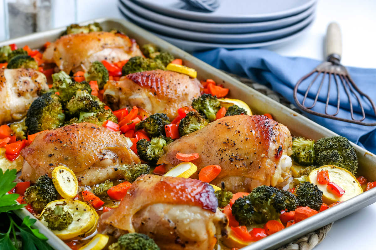 Sheet Pan Chicken Dinner with plates and forks in the background.