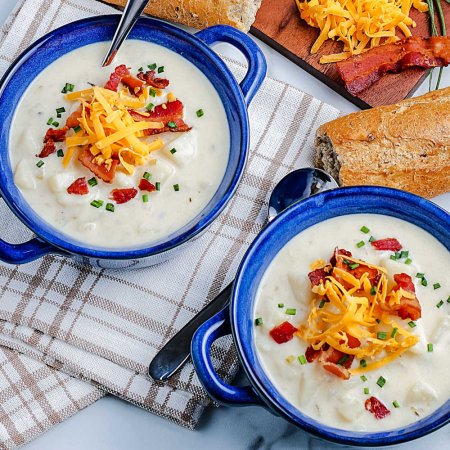 An overhead picture of the finished Instant Pot Potato Soup recipe inside od blue soup bowls.