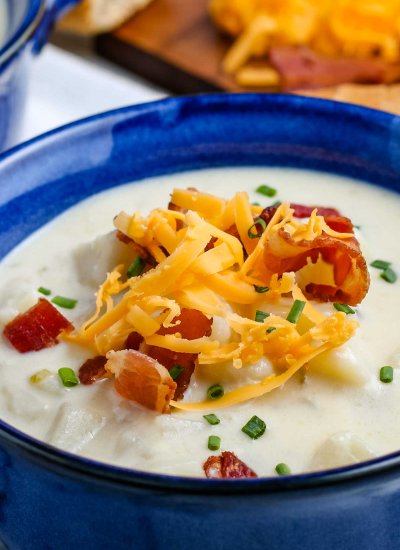A close up picture of the finished Instant Pot Potato Soup loaded with toppings.