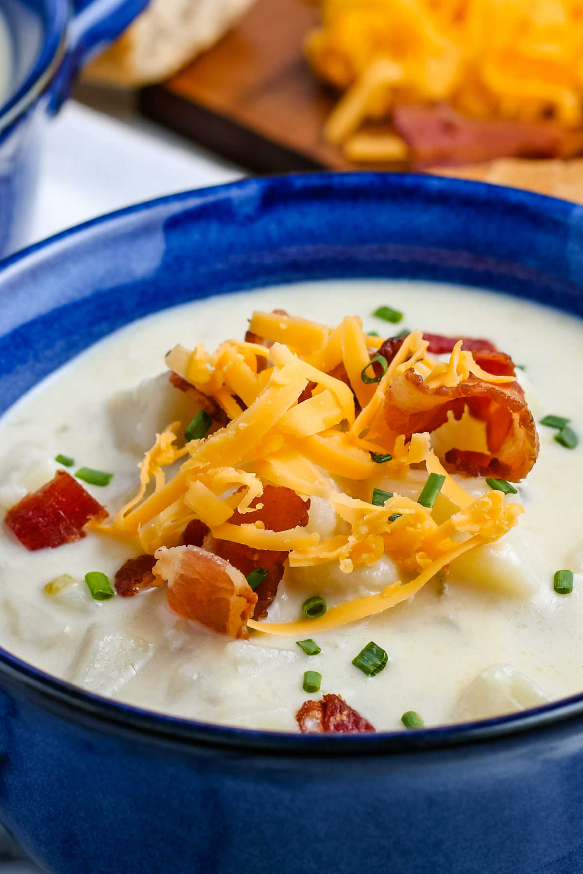 A close up picture of the finished Instant Pot Potato Soup loaded with toppings.