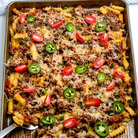 A serving spoon scooping up some Nacho Fries.