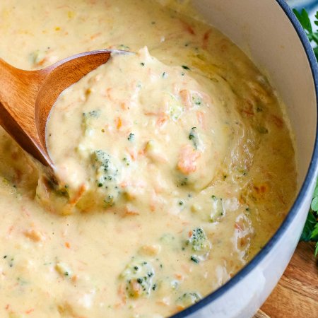A wooden ladle in the finished Broccoli Cheddar Soup recipe.