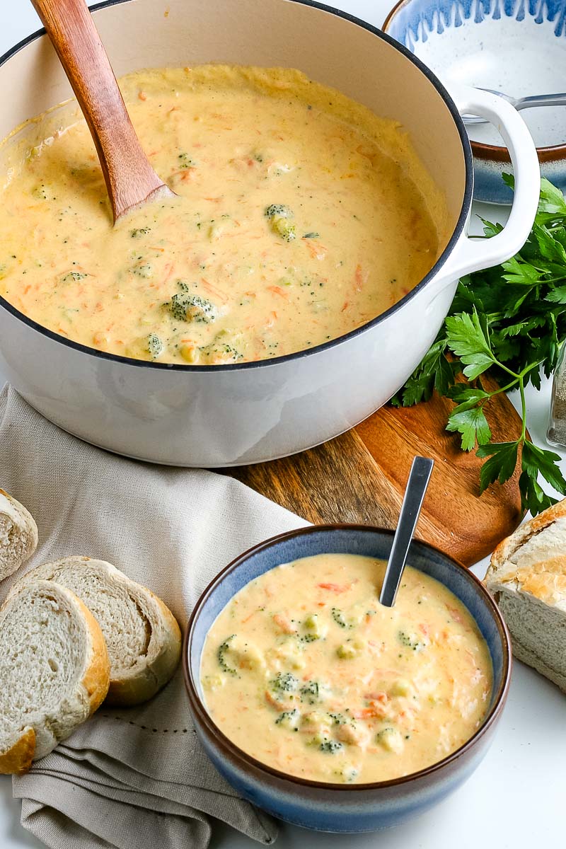 The finished Broccoli Cheddar Soup in a soup pot and in a blue bowl.