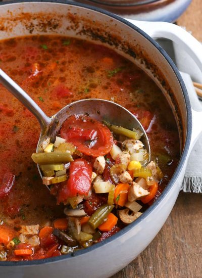 A ladle picking up some Chicken Vegetable Soup.