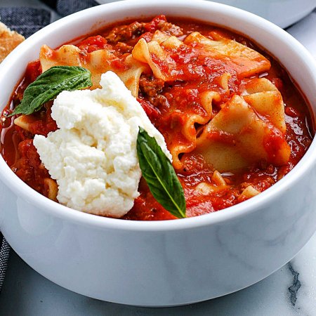 A close up picture of the finished Crockpot Lasagna Soup garnished with ricotta cheese.