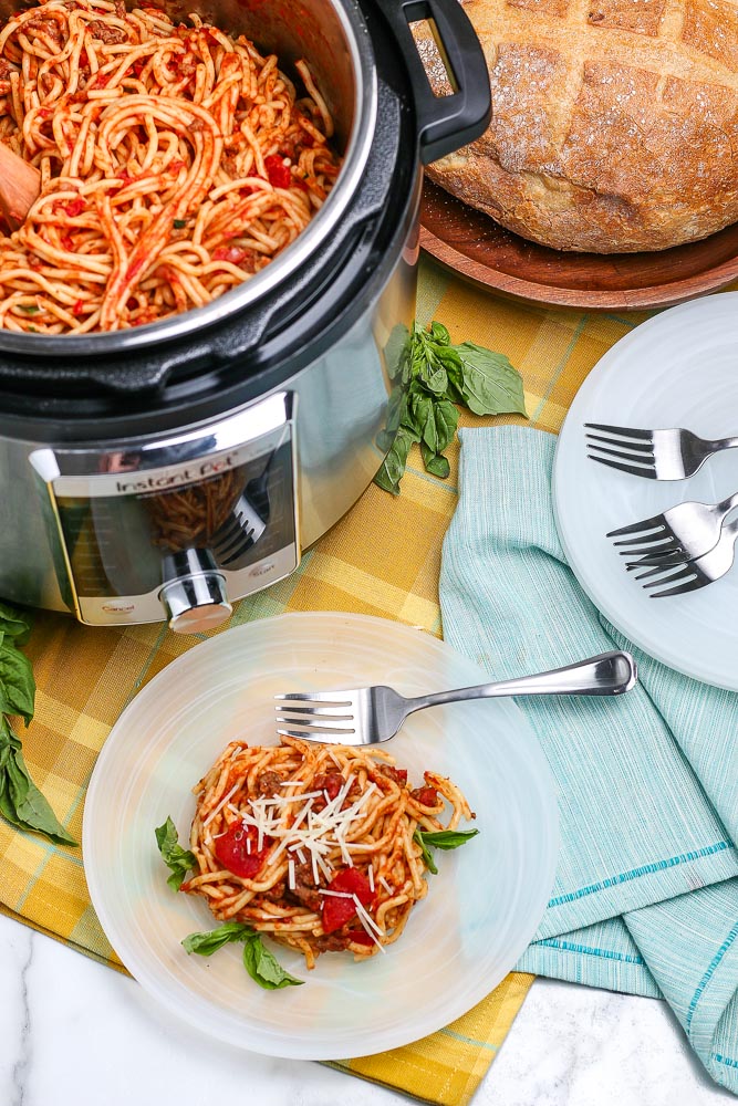 Instant Pot Spaghetti on a white plate plus more in the instant pot.