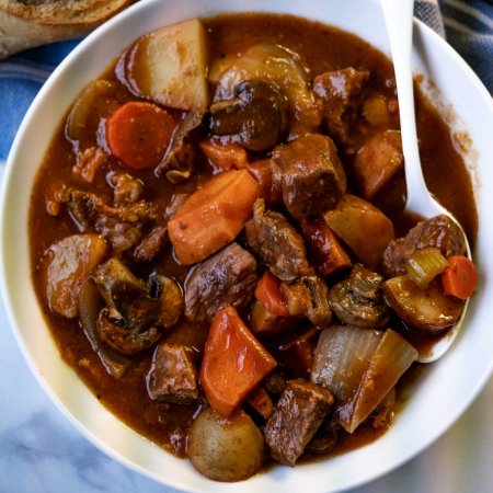 Gone All Day Stew with a white bowl and a white spoon.