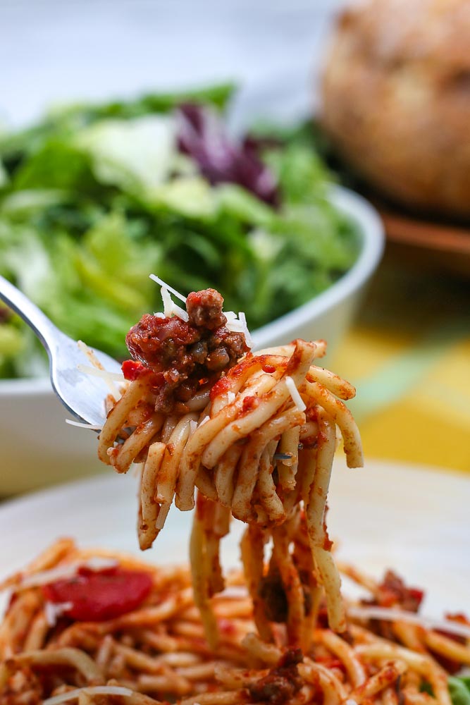 A fork picking up some spaghetti and meat sauce.